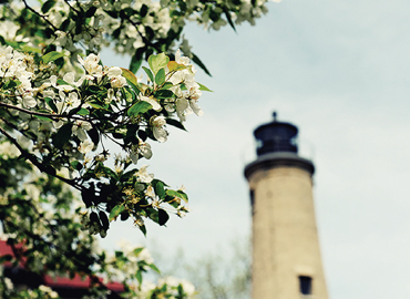 A lighthouse appears through the trees during a beautiful spring day in Kenosha.